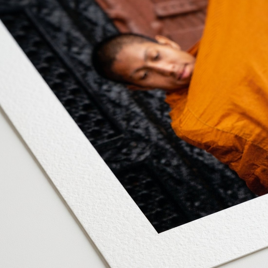 Corner of an unframed fine art print, showing the textured white paper border around the image